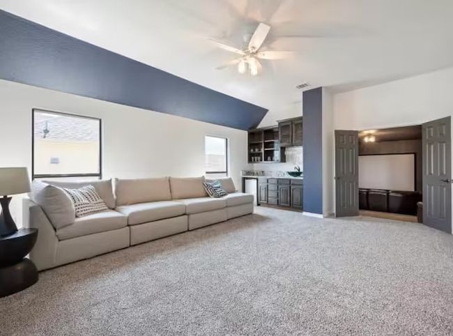 Living room featuring a ceiling fan, lofted ceiling, and light carpet | Image 10