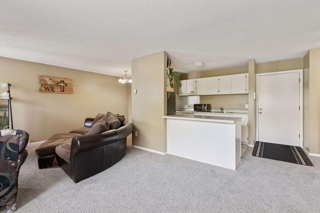 Cozy living room area with easy access to kitchen and dining. | Image 13