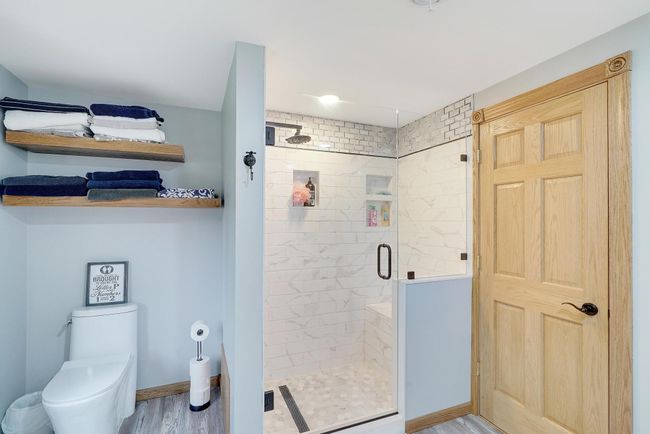 Beautiful custom walk-in tiled shower and new toilet and open shelving. | Image 23