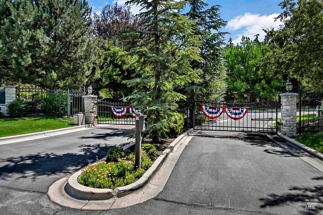 View of asphalt street featuring a gate, curbs, street lighting, and a gated entry | Image 29