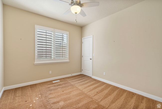 Unfurnished room with carpet floors, a ceiling fan, a textured ceiling, baseboards, and visible vents | Image 20