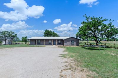 Ranch-style home with a front lawn and a trampoline | Image 1