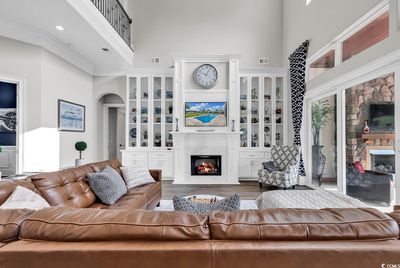 Living room featuring ornamental molding, a high ceiling, and hardwood / wood-style floors | Image 3