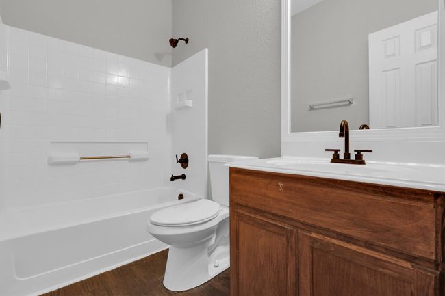 Bathroom with vanity, bathtub / shower combination, toilet, and wood finished floors | Image 16