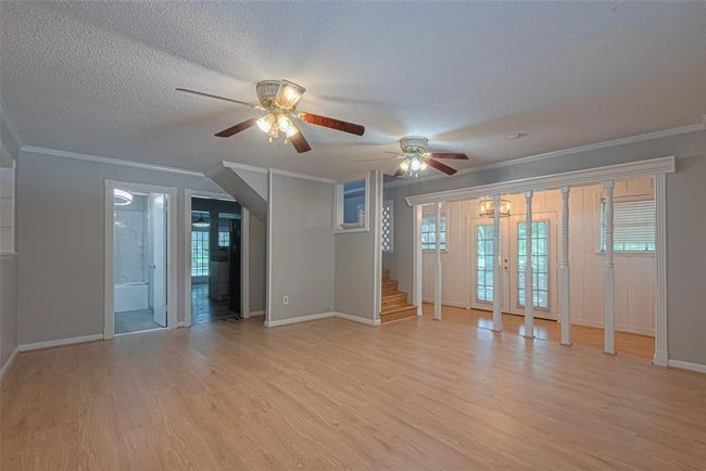 Spacious living room to enjoy time with the family detailed with built-in display cases and crown molding. | Image 11