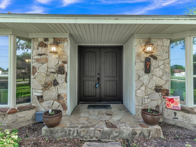 Doorway to property featuring stone siding | Image 4