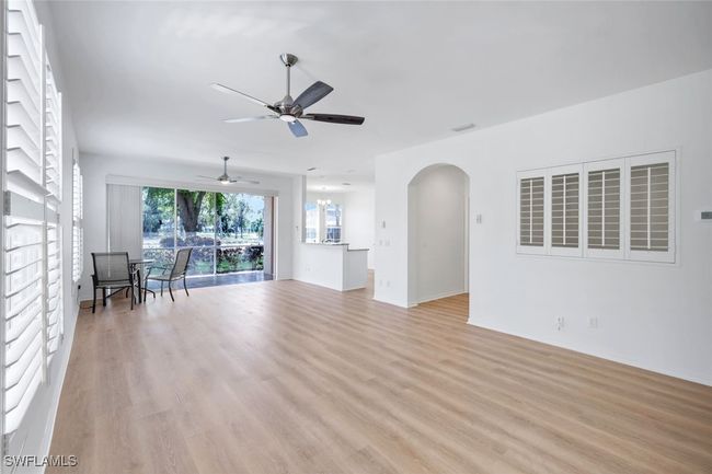 Unfurnished living room featuring ceiling fan, light wood-type flooring, and arched walkways | Image 5