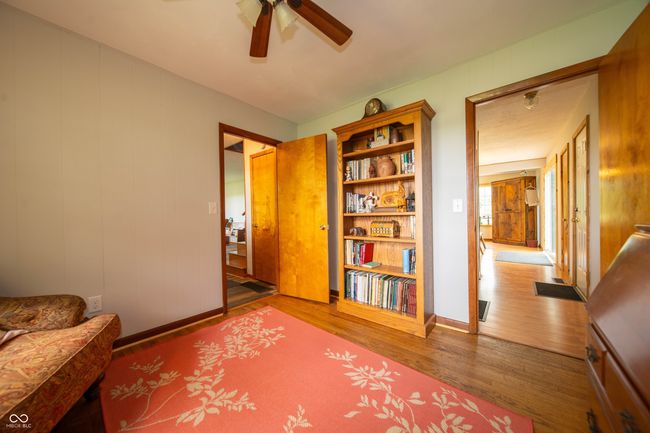 living area featuring wood finished floors, a ceiling fan, and baseboards | Image 12