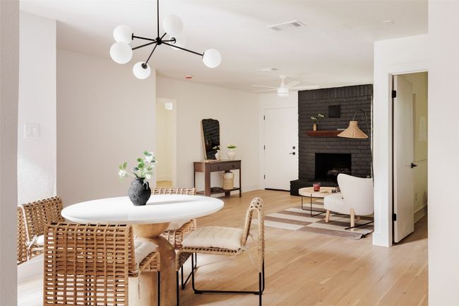 Dining room with light wood finished floors, a chandelier, and a brick fireplace | Image 7