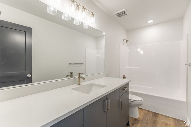 Full bathroom with toilet, vanity, shower / tub combination, and wood finished floors | Image 14