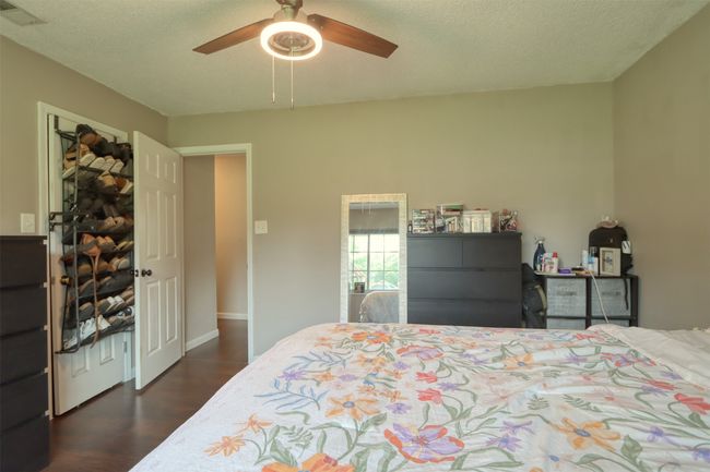 Bedroom with dark wood-style floors and a ceiling fan | Image 37