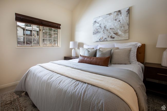 Bedroom with carpet floors and lofted ceiling | Image 14