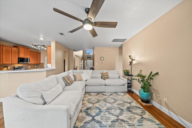 Living area with ceiling fan, wood finished floors, and baseboards | Image 17