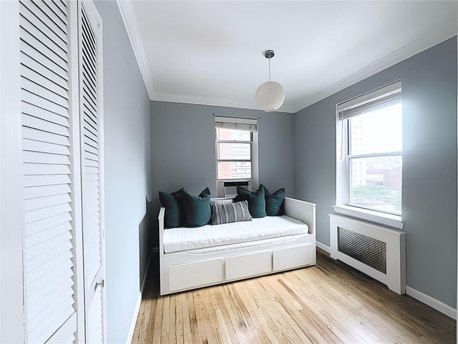 Bedroom with ornamental molding, multiple windows, light wood-type flooring, and radiator | Image 11