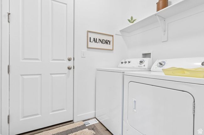 Washroom featuring laundry area, washer and dryer, and wood finished floors | Image 13