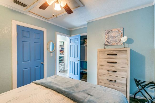 Bedroom featuring a ceiling fan, crown molding, and visible vents | Image 17