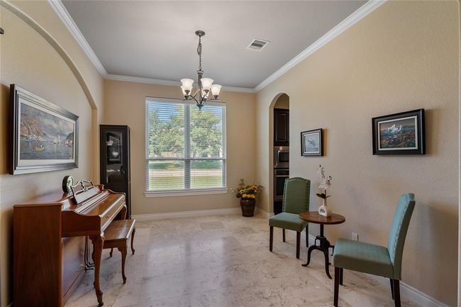 The well-proportioned dining room has much natural lighting and architectural details. | Image 9