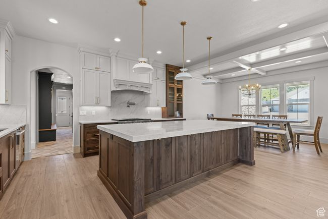 Kitchen with a large island, recessed lighting, backsplash, arched walkways, and light wood-style floors | Image 8