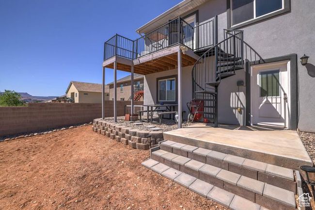 Rear view of house featuring stairs, a fenced backyard, stucco siding, a wooden deck, and a patio | Image 27