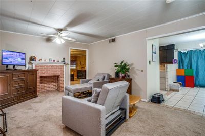 Living room with ceiling fan, crown molding, and light carpet | Image 2