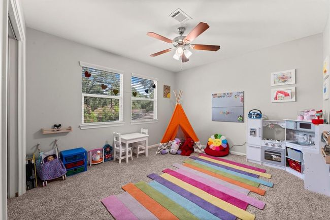 Bright and inviting children's room with soft carpet and ample natural light. | Image 32