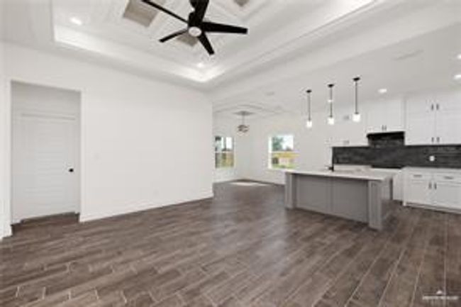 Kitchen featuring white cabinets, dark wood-style floors, open floor plan, recessed lighting, and ceiling fan | Image 6