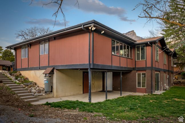 Rear view of house with a yard, stairway, and a patio | Image 26