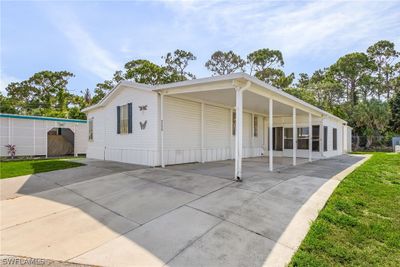 View of front facade with a front lawn and a carport | Image 1