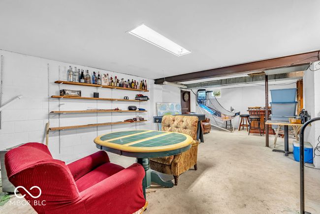 playroom featuring unfinished concrete flooring and concrete block wall | Image 40