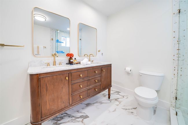 Bathroom with vanity, a shower with door, and toilet | Image 20