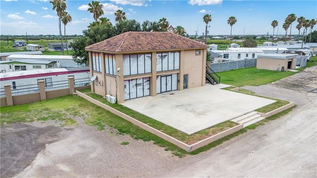 Back of property with stucco siding, stairs, a tiled roof, and a residential view | Image 4