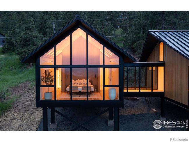 The incredible private primary suite connects with a glass walkway and overlooks a meadow with abundant wildlife and twinkling lights below | Image 17