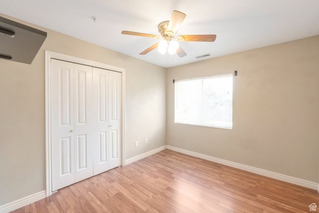 Unfurnished bedroom with light wood-style flooring, a closet, and a ceiling fan | Image 15