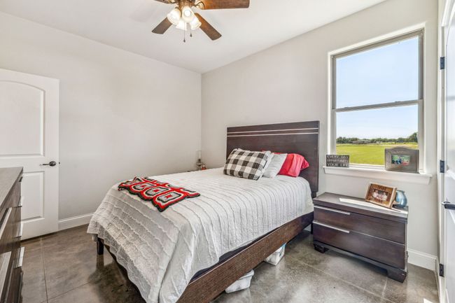 Bedroom featuring baseboards, concrete floors, and ceiling fan | Image 21