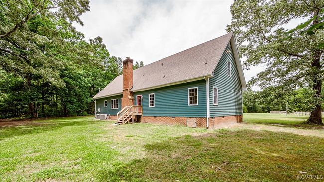 Back of property with a chimney, a lawn, crawl space, and cooling unit | Image 35