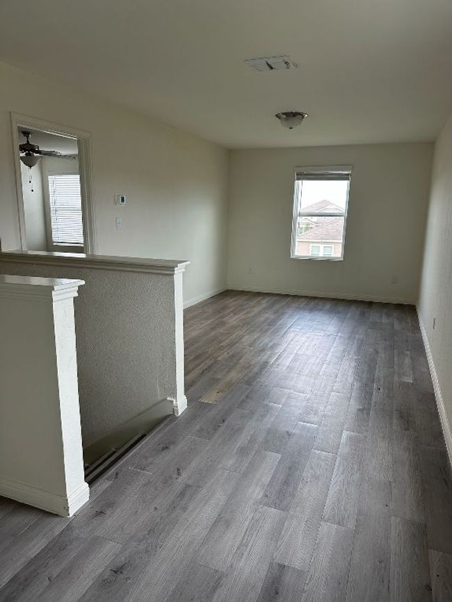 Unfurnished living room with healthy amount of natural light and wood finished floors | Image 20