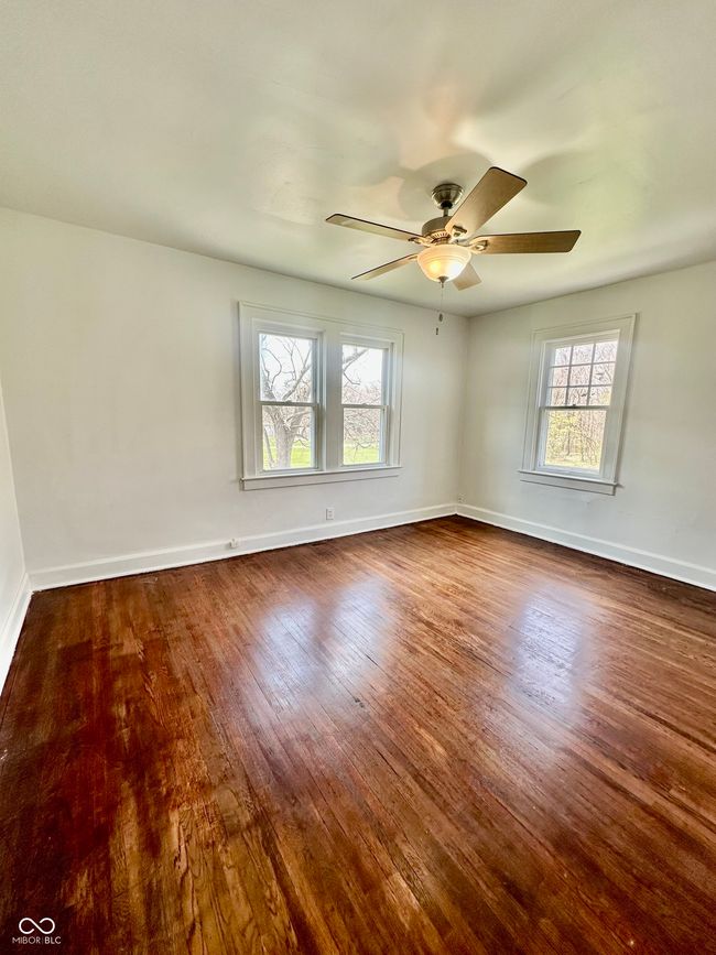 unfurnished room featuring baseboards, a ceiling fan, and dark wood-style floors | Image 36
