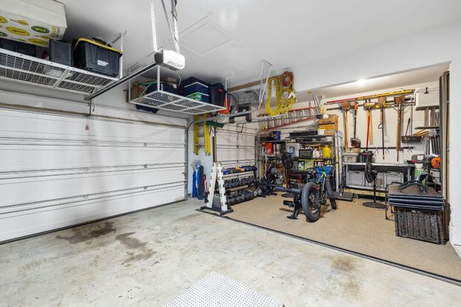 3 car garage featuring a garage door opener and storage above the garage doors | Image 37