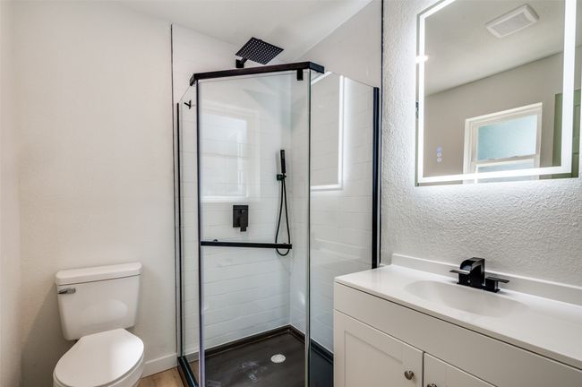 Full bath with vanity, a stall shower, a textured wall, and wood finished floors | Image 13