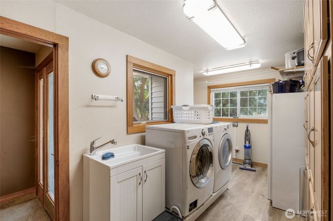 Spacious laundry room with wall to wall built in storage. Washer and dryer are included. | Image 28