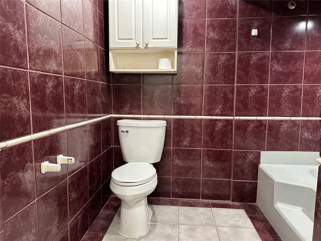 Bathroom featuring tile walls, toilet, and tile patterned floors | Image 5
