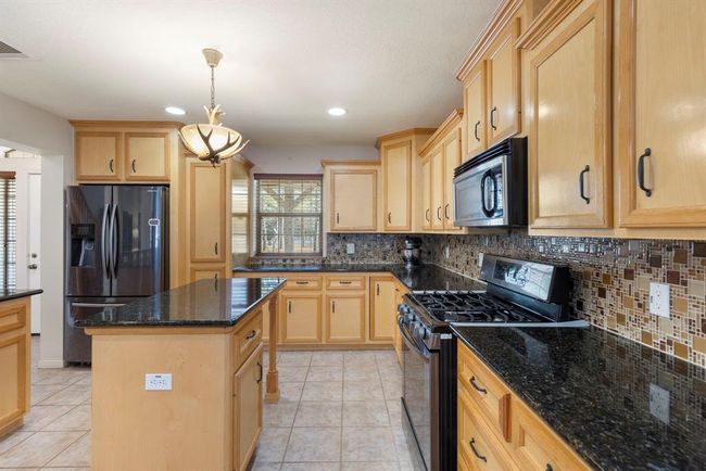 Kitchen is complete with gas stove and granite countertops. | Image 15