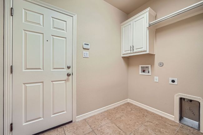 Laundry room featuring hookup for an electric dryer, hookup for a washing machine, gas dryer hookup, and cabinet space | Image 25