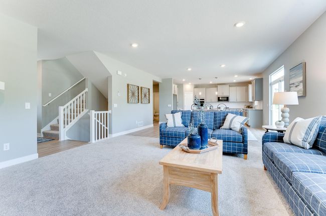 The rest of the main level pours out from the home's kitchen, as the layout flows seamlessly from the kitchen space into the dining and living areas! Photo of model home, color and options will vary. | Image 4