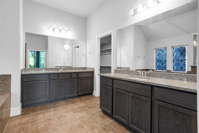 Experience luxury in the master suite, featuring dual vanities, a soaking tub, and a separate shower. | Image 25