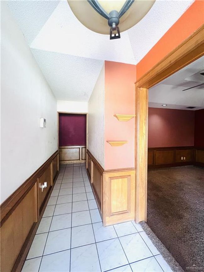 Hallway with a textured ceiling and light colored carpet | Image 4