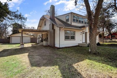 Back of house with a garage, a yard, a carport, and an outdoor structure | Image 2