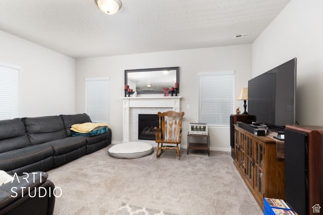 Carpeted living room with a fireplace and baseboards | Image 8