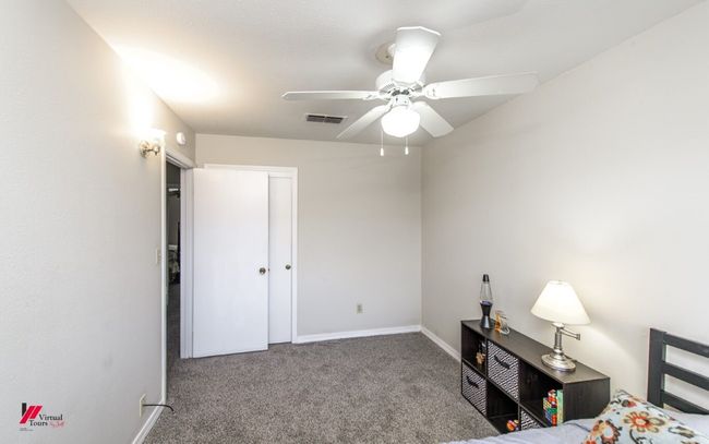 Carpeted bedroom with a ceiling fan, baseboards, and visible vents | Image 23
