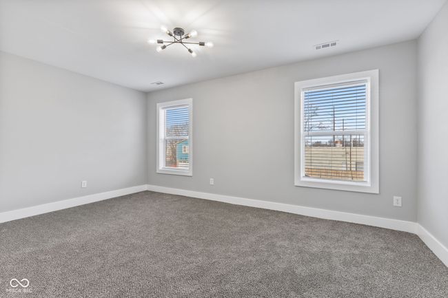 BR 3 featuring baseboards, a notable chandelier, dark colored carpet, and visible vents | Image 25